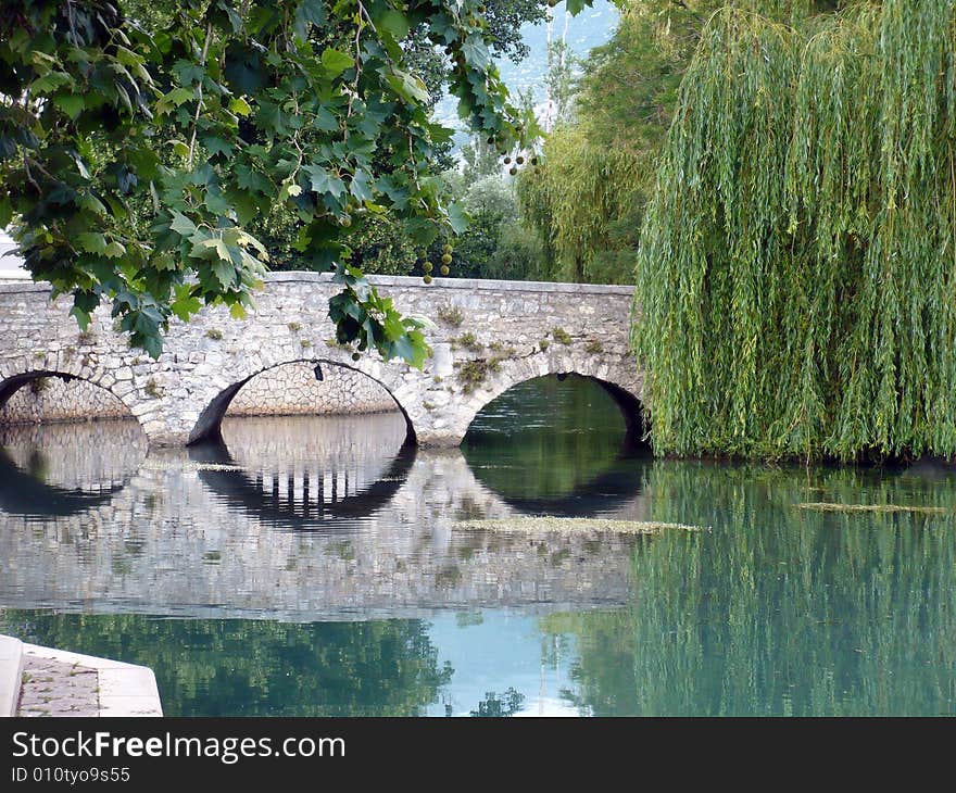 Old stone bridge reflection in the river