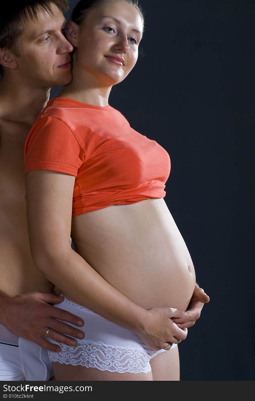 The man and woman with child standing against black background. The man and woman with child standing against black background