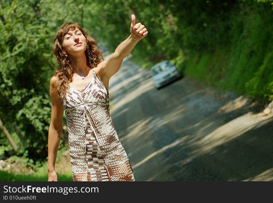 Pretty girl hitching hiking on country road. Pretty girl hitching hiking on country road.