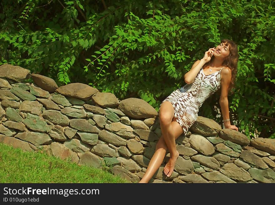 Pretty girl talking on cell phone outside. Pretty girl talking on cell phone outside.