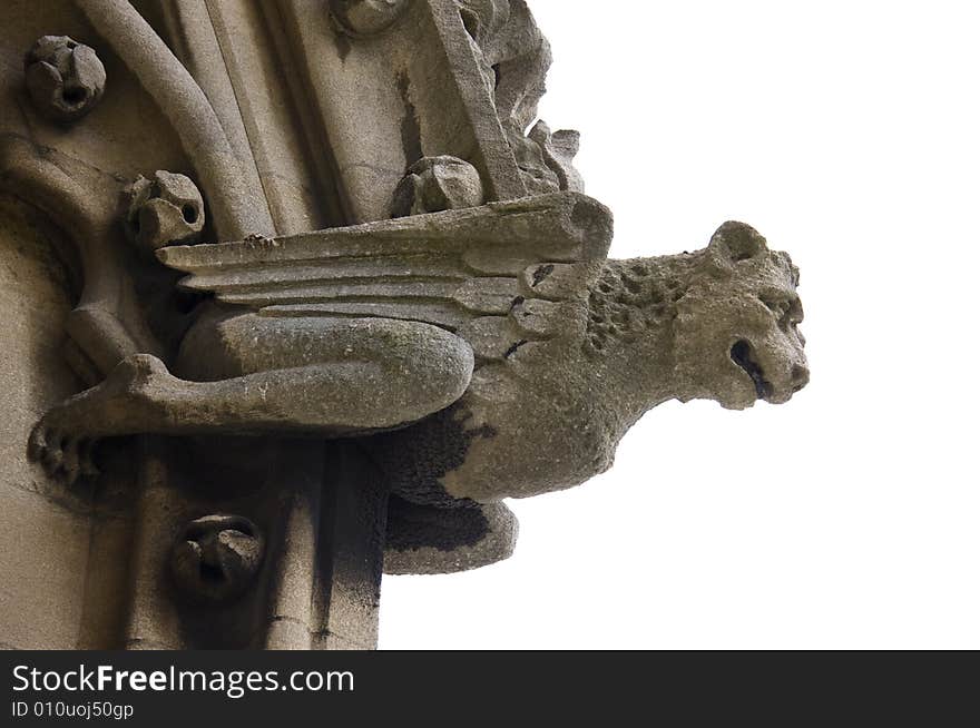 A gargoyle of a winged creature projects from the side of a church in Oxford, England. A gargoyle of a winged creature projects from the side of a church in Oxford, England.