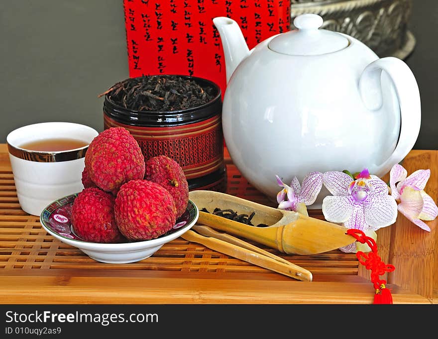 Asian pottery tea set with chinese tea and litchees