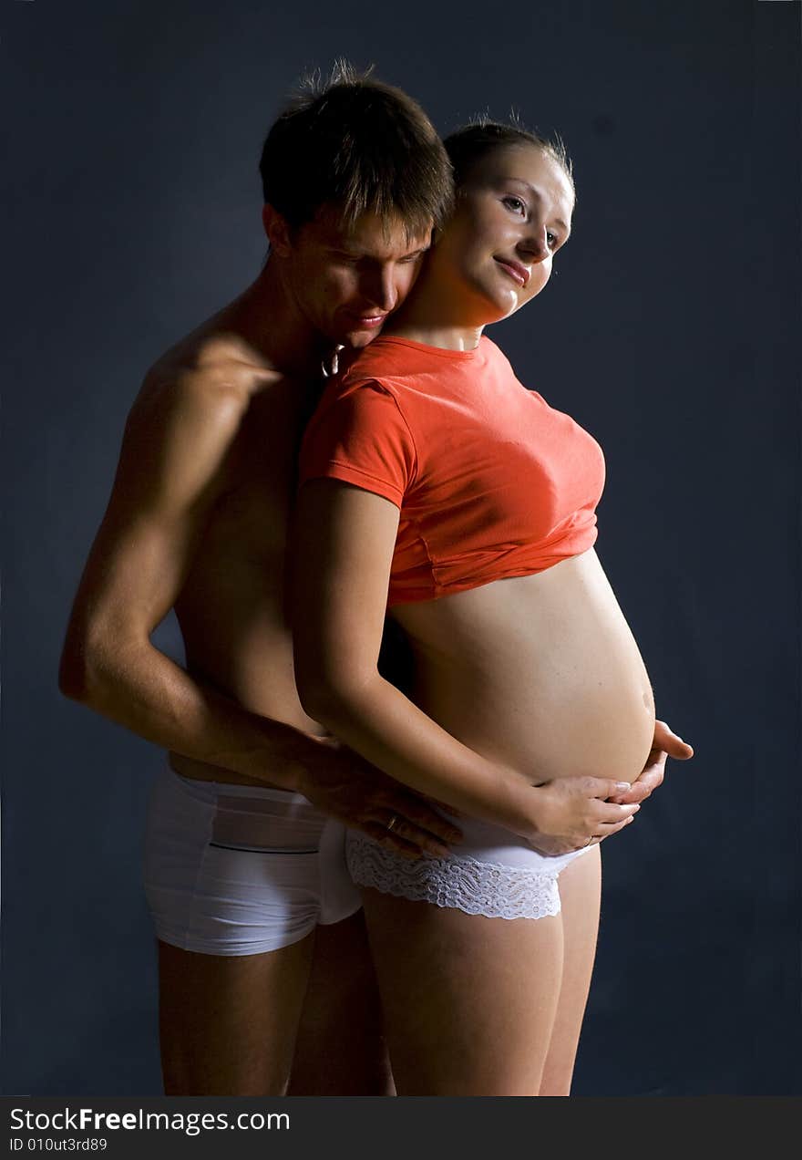 The man and woman with child standing against black background. The man and woman with child standing against black background