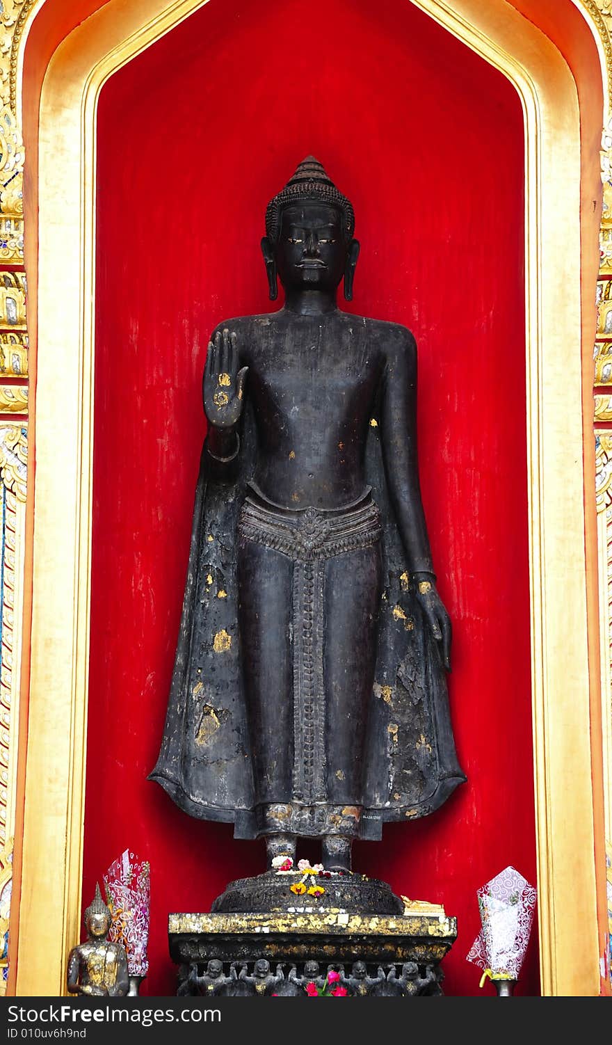 Thailand, the Wat Benchamabophit or the Marble temple in the city of Bangkok constructed in 1900 is faced with white Carrara marble.View of an outsider standing Buddha inside a red niche. Thailand, the Wat Benchamabophit or the Marble temple in the city of Bangkok constructed in 1900 is faced with white Carrara marble.View of an outsider standing Buddha inside a red niche