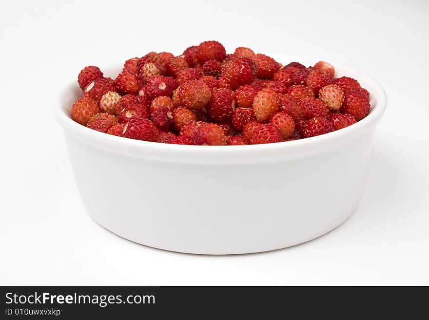 A close-up of a bowl of fresh wild strawberry