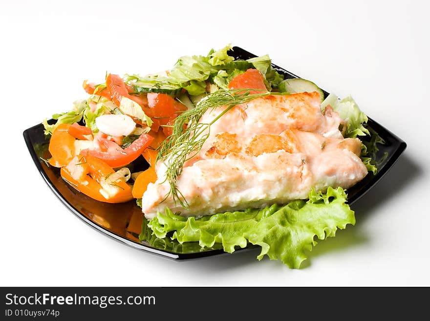 Stake from a salmon with vegetables on a plate. Closeup.