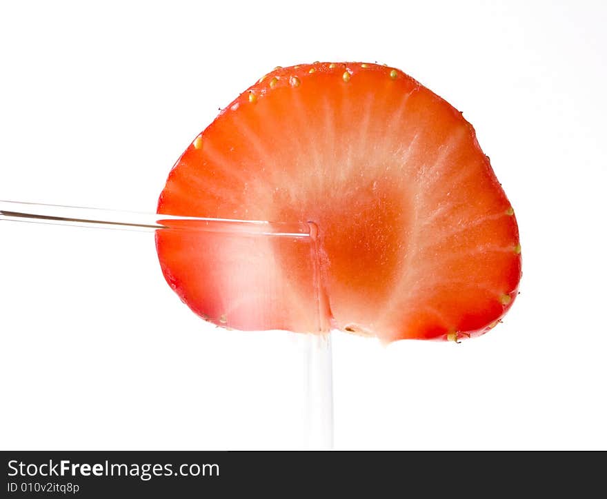 Half of strawberry on glass on white ground