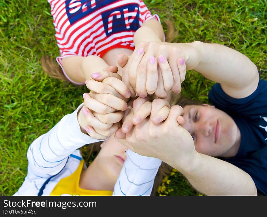 Three friends lay on a grass