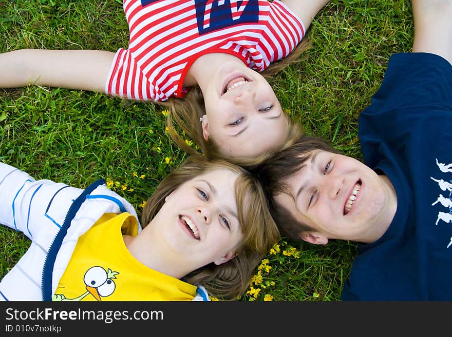 Three Friends Lay On A Grass