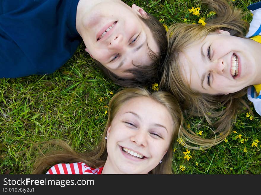 Three happy friends lay on a grass. Three happy friends lay on a grass