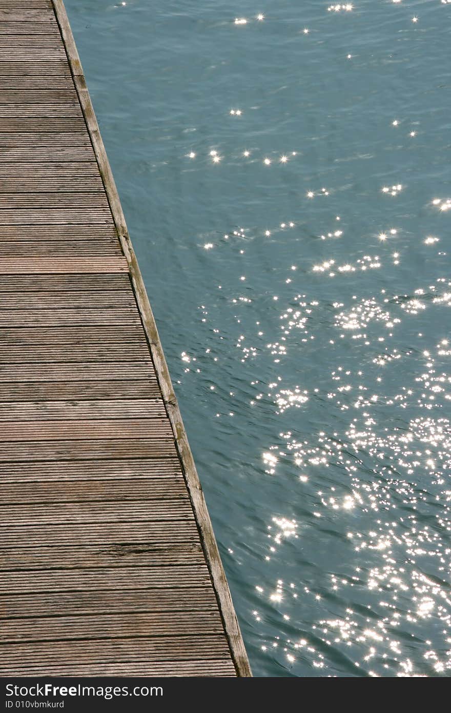 Timber jetty with glistening blue water