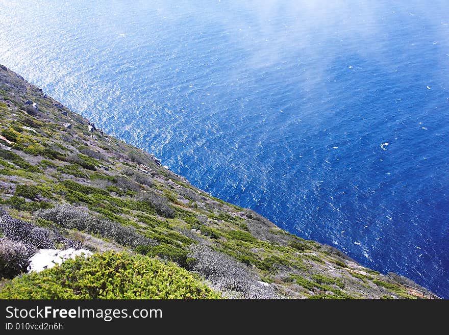 Over the edge of the green precipice lays the blue ocean