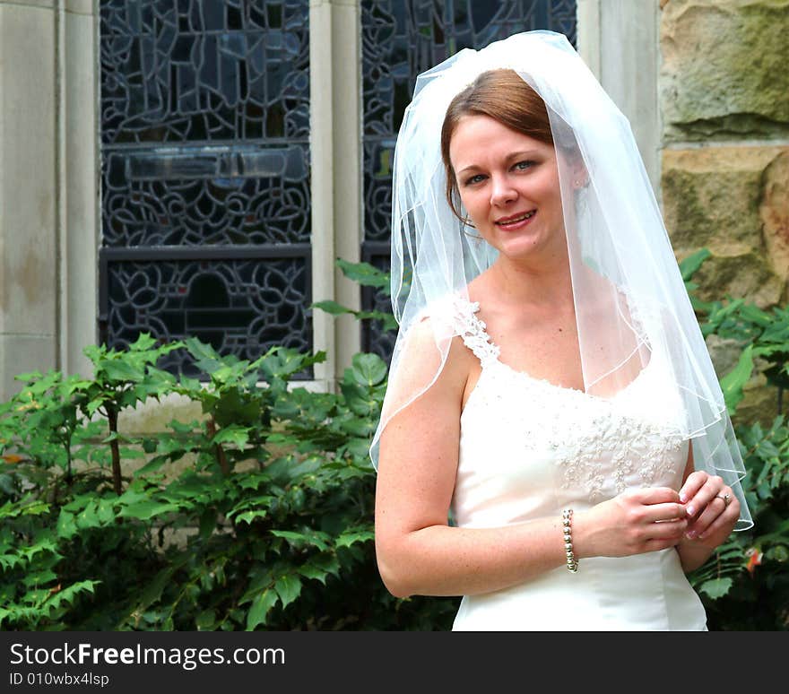 View of bride outside near stained glass window