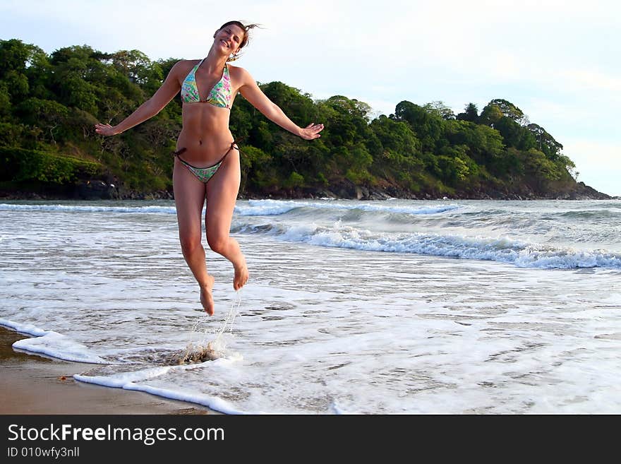 Young woman is jumping happily on the beach. Ideal shot for vacation or summer. Young woman is jumping happily on the beach. Ideal shot for vacation or summer.