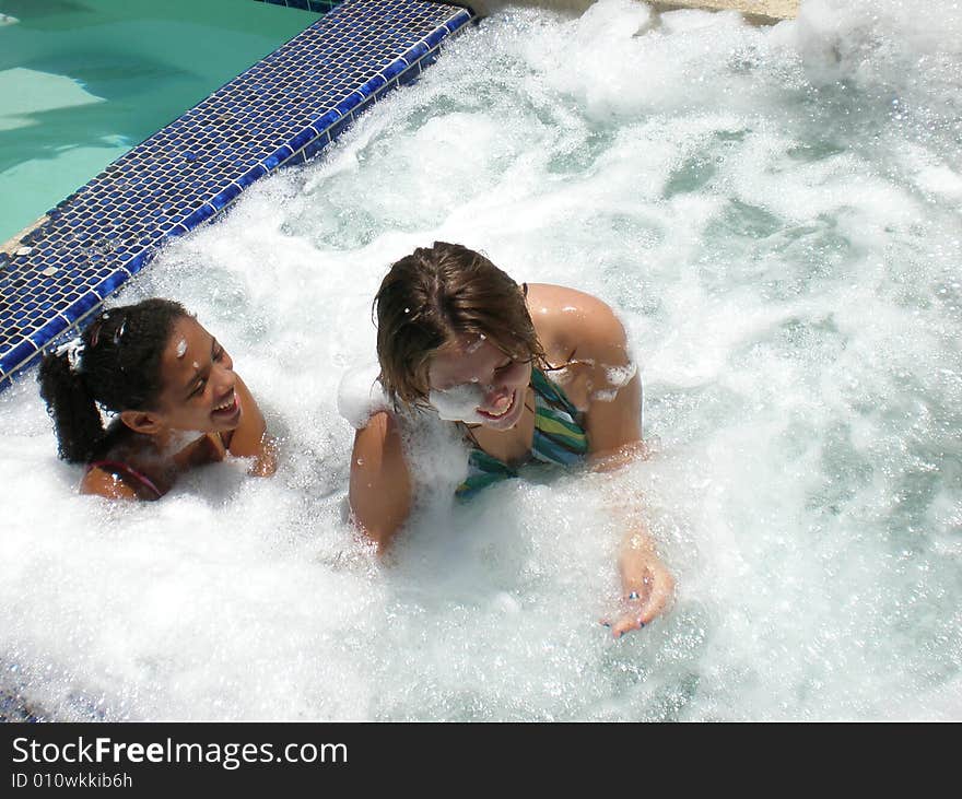 A picture of two friends who are best friends playing and splashing each other in a jacuzzi. A picture of two friends who are best friends playing and splashing each other in a jacuzzi.