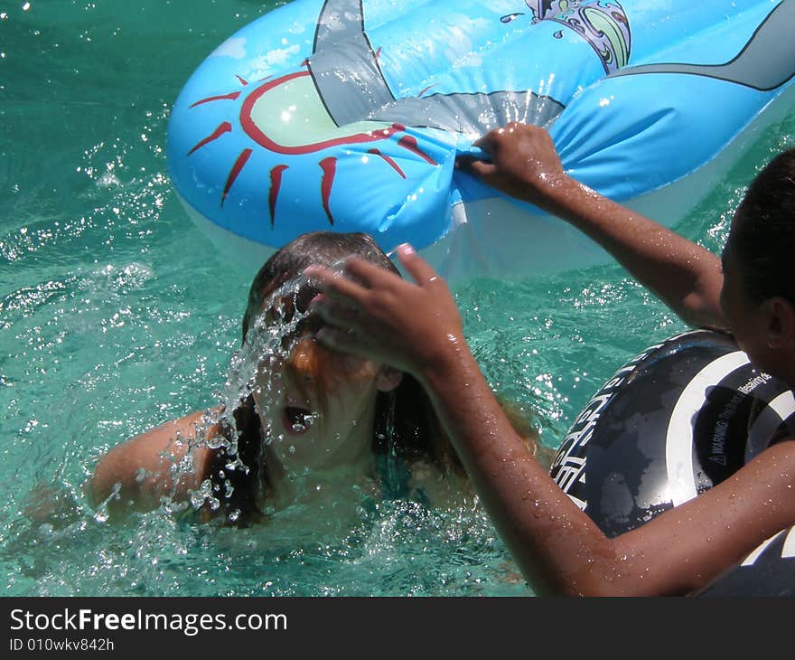 A picture of two teen girls playing in the swimming pool. A picture of two teen girls playing in the swimming pool.