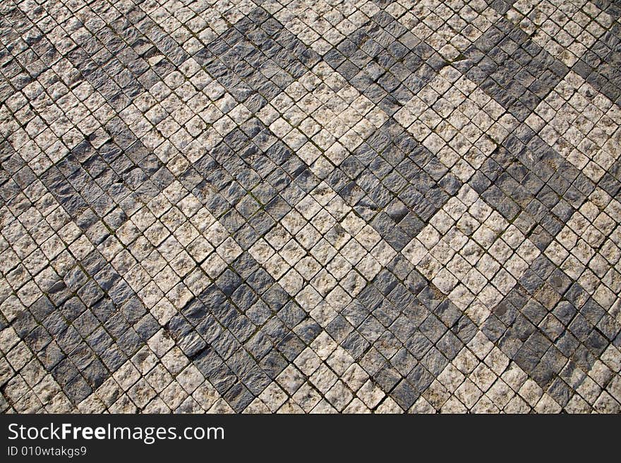 Stone design in Prague sidewalk. Background texture.