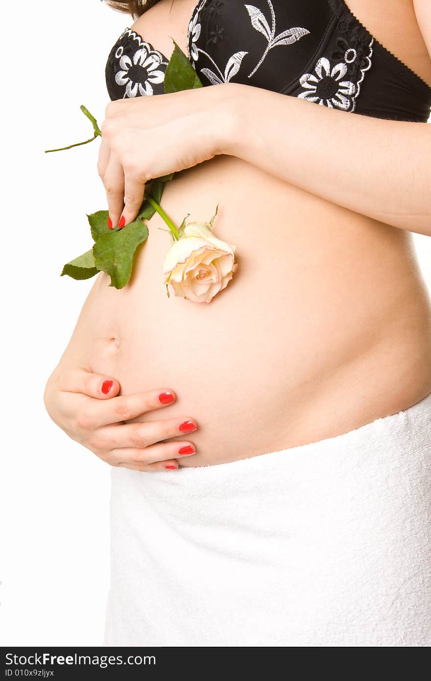 Pregnant woman holding her belly and flower