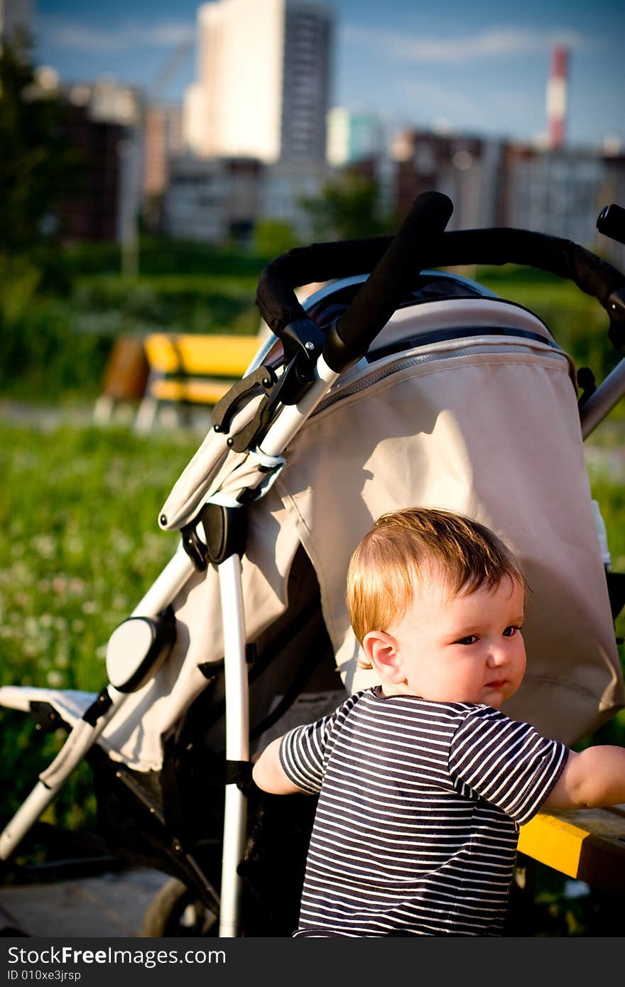 Sad baby hiding behind the stroller