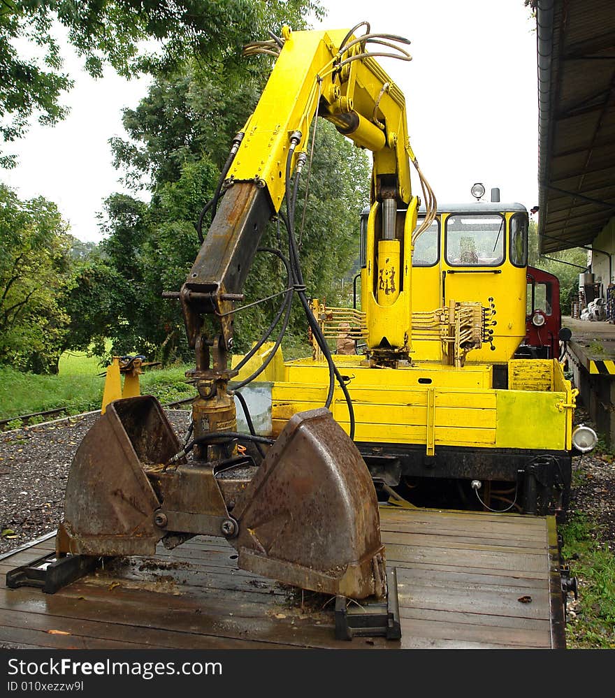 Yellow Railway dredge on a platform at small railway station in Bavaria.