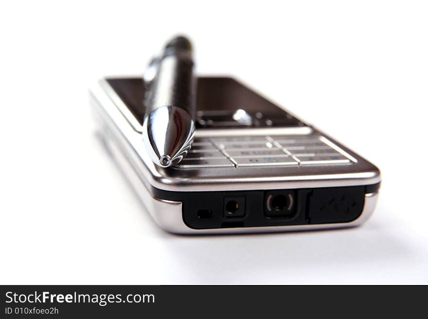 Silver mobile phone and pen close-up isolated on white background