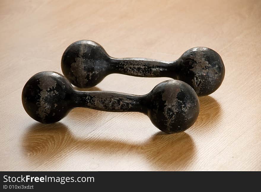 Greater dumbbells on a floor of a sports hall