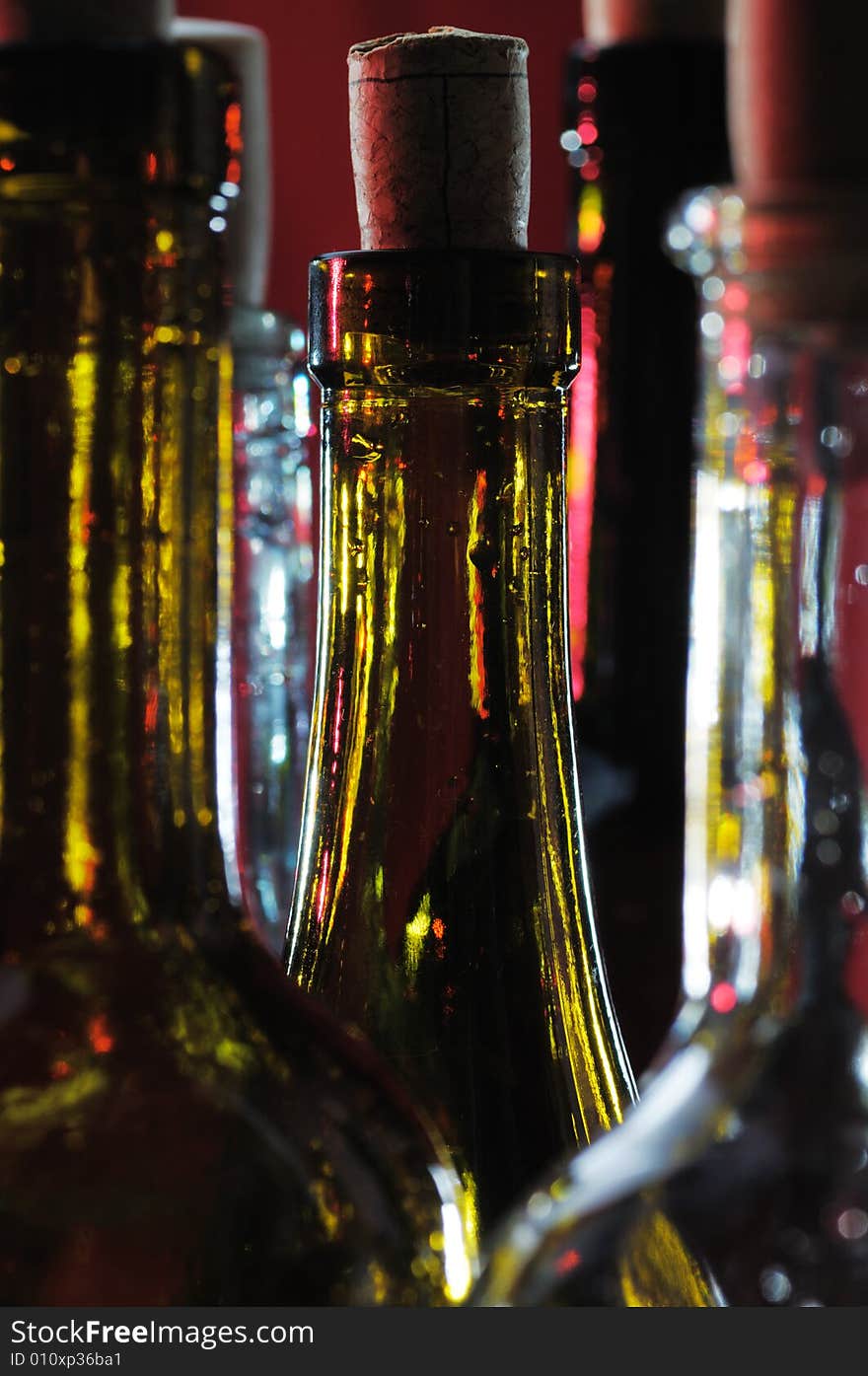 Wine bottles on the red background. Narrow depth of field. Wine bottles on the red background. Narrow depth of field.