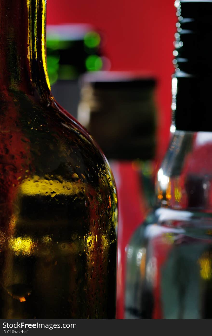 Wine bottles on the red background. Narrow depth of field. Wine bottles on the red background. Narrow depth of field.