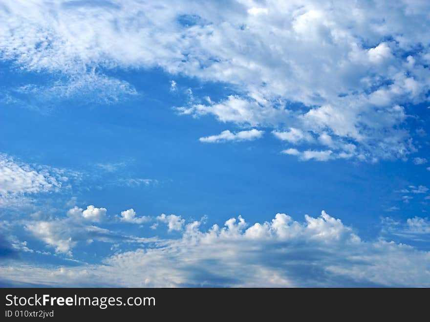 The sky is filled with bright clouds in the late afternoon with a path of clear blue. The sky is filled with bright clouds in the late afternoon with a path of clear blue