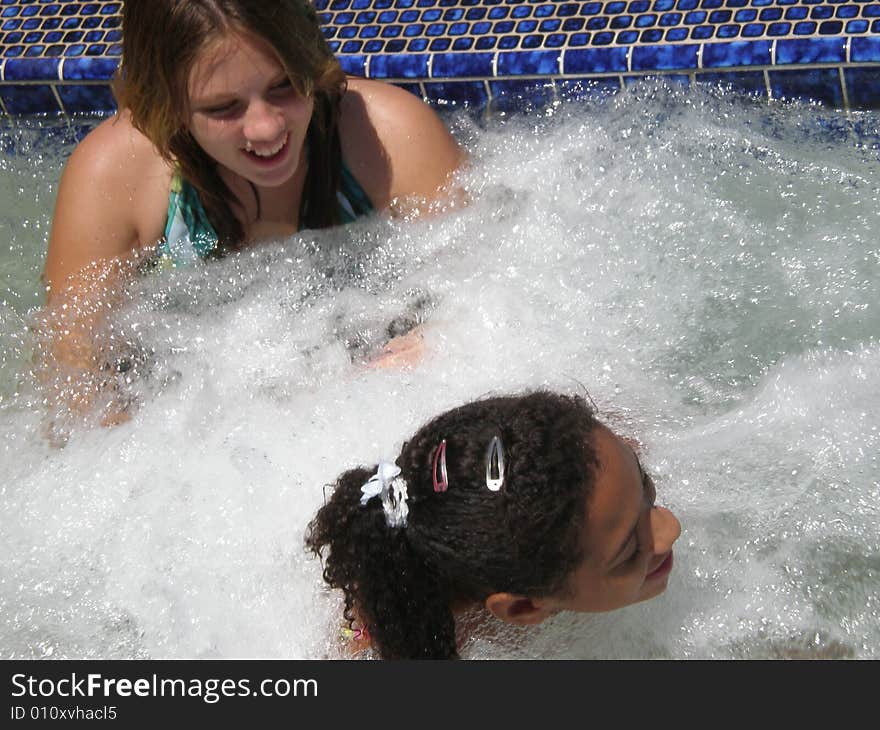 A picture of two girls who are best friends talking and playing in jacuzzi bubbles. A picture of two girls who are best friends talking and playing in jacuzzi bubbles.