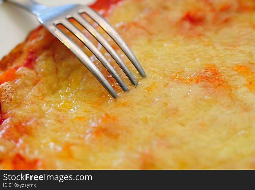 Close shot about a little tomato and mozzarella cheese pizza, with a fork. Close shot about a little tomato and mozzarella cheese pizza, with a fork.