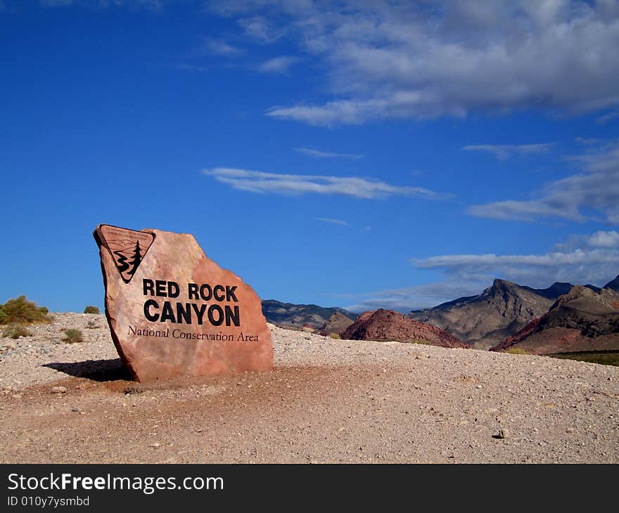 Red Rock Canyon National Conservation Area welcome sign.
Beige and red rocks make up hills. Red Rock Canyon National Conservation Area welcome sign.
Beige and red rocks make up hills