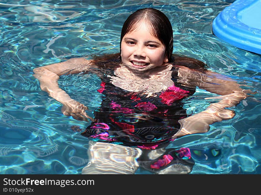 Young girl of 12 having fun in a swimming pool.  She has brown eyes and hair and is of Asian and Caucasian background, multi-racial. Young girl of 12 having fun in a swimming pool.  She has brown eyes and hair and is of Asian and Caucasian background, multi-racial.