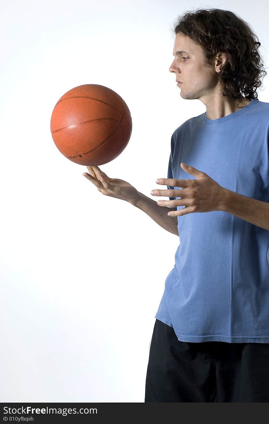 Man balances a basketball on his finger - Vertically framed photograph. Man balances a basketball on his finger - Vertically framed photograph