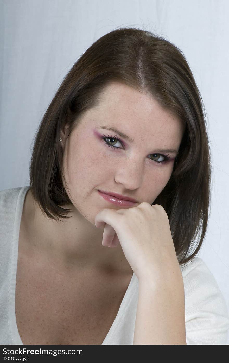 A portrait of a young woman in a white v neck sweater. A portrait of a young woman in a white v neck sweater