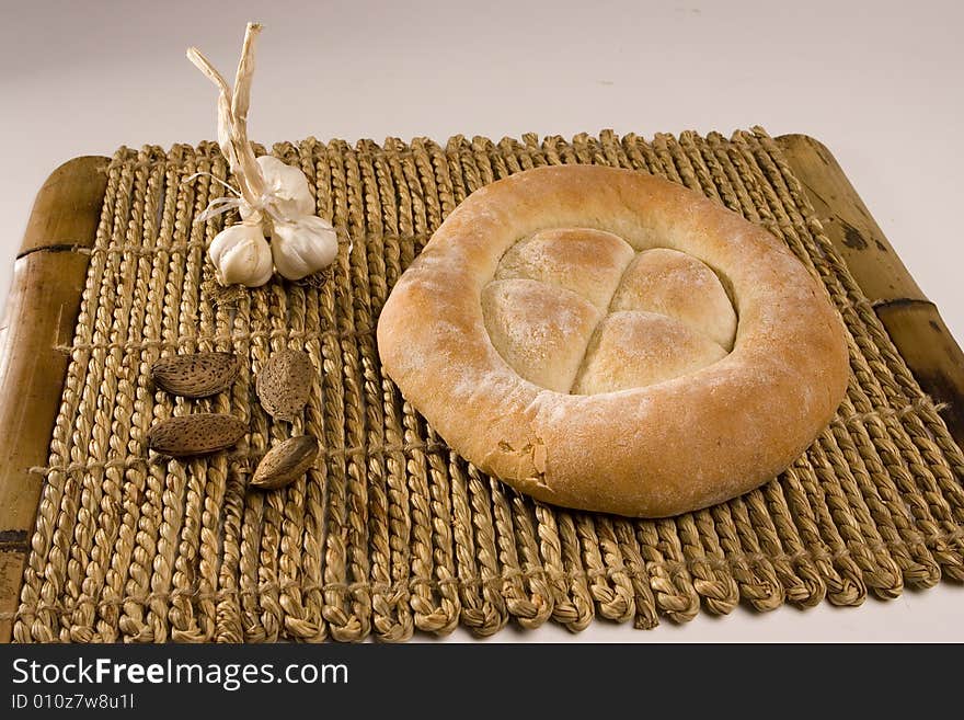 Made in the studio, bread, garlic and almonds on wood isolated on white; healthy food