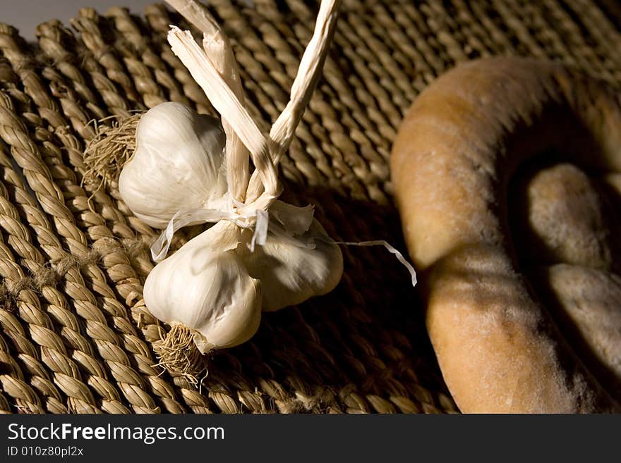 Garlic, made in the studio; healty medicine; bread in the background. Garlic, made in the studio; healty medicine; bread in the background