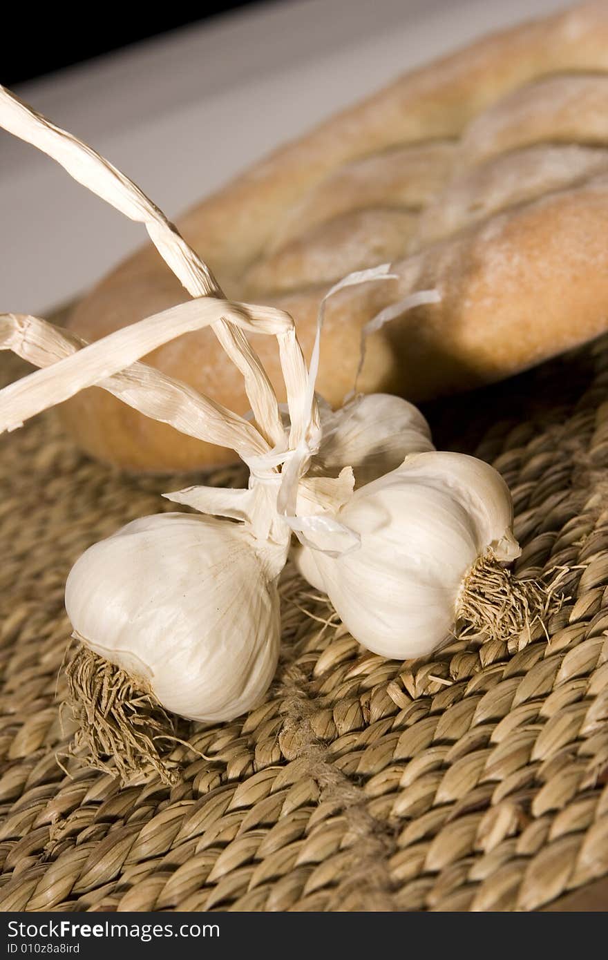 Garlic, made in the studio; healty medicine; bread in the background. Garlic, made in the studio; healty medicine; bread in the background