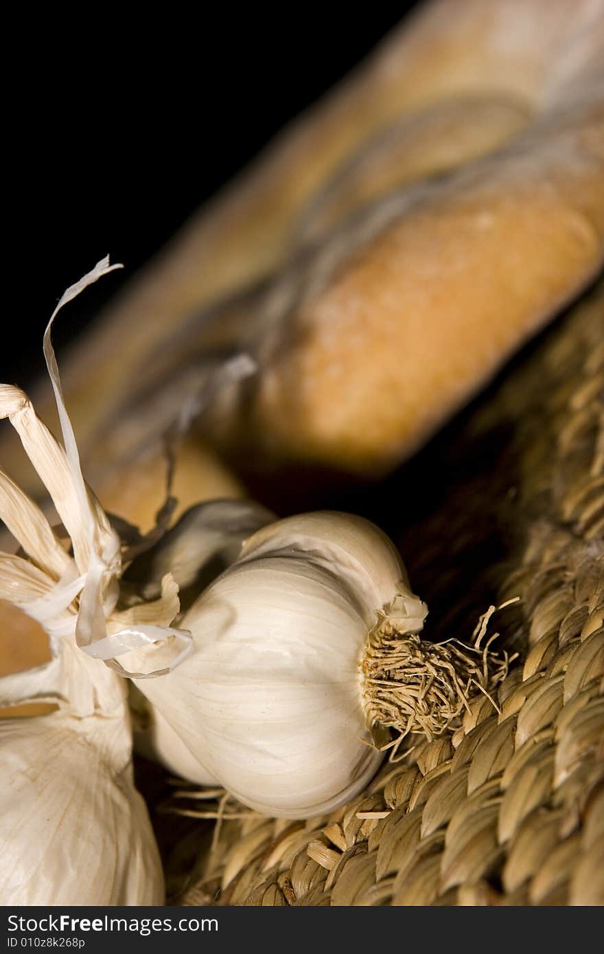 Garlic, made in the studio; healty medicine; bread in the background. Garlic, made in the studio; healty medicine; bread in the background