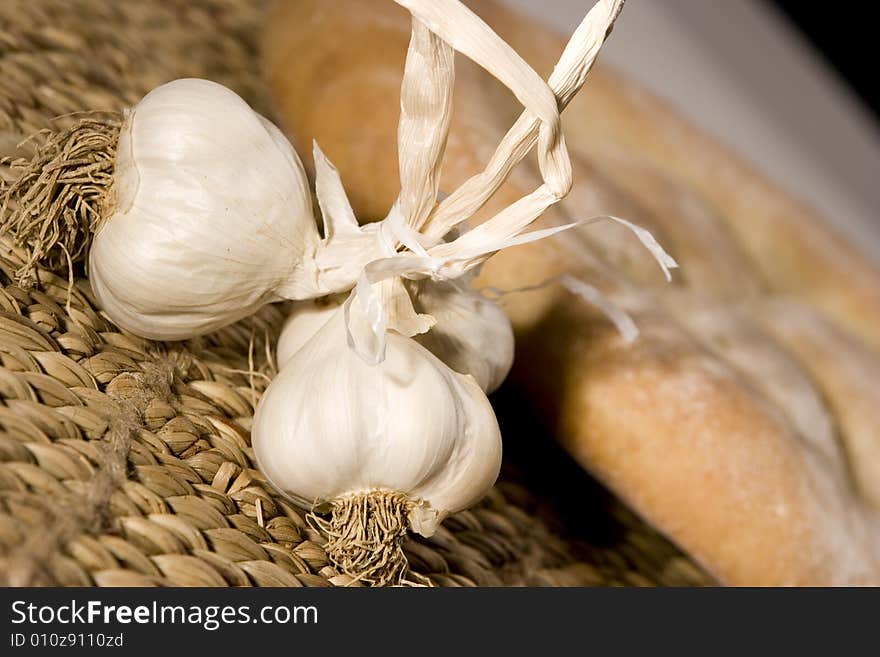 Garlic, made in the studio; healty medicine; bread in the background. Garlic, made in the studio; healty medicine; bread in the background