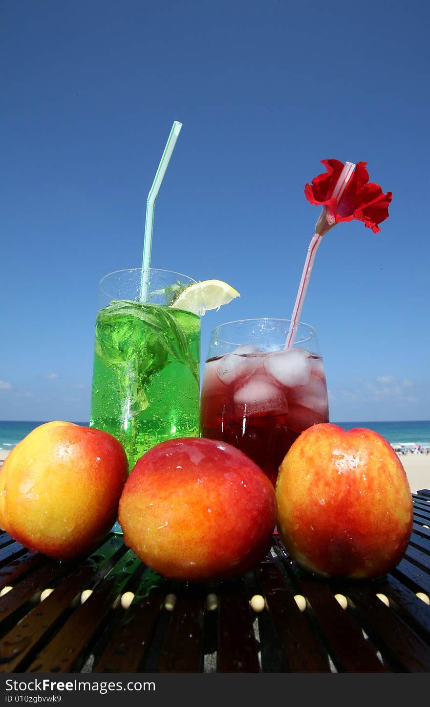 Green and red drink with icecubes in glasses on the blue sky backgraunds. Green and red drink with icecubes in glasses on the blue sky backgraunds