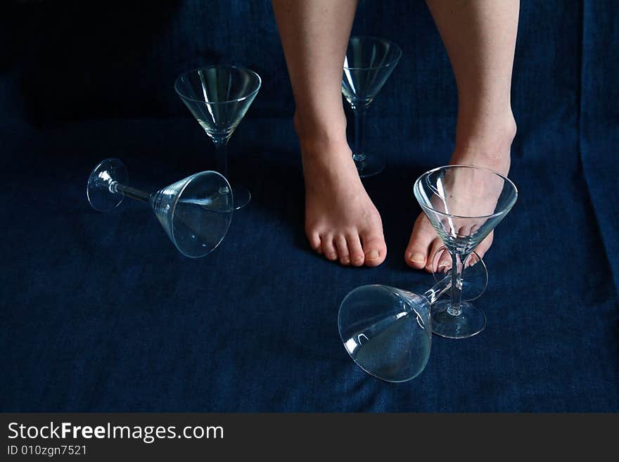 Female legs and five glasses for martini. Female legs and five glasses for martini