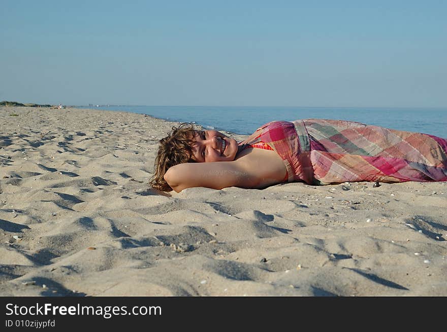 Smiling girl lying on beach