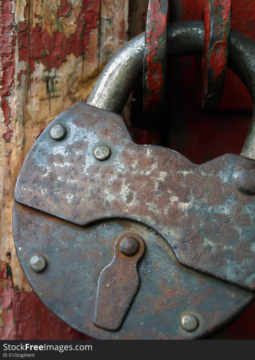 The closed, old, rusty hinged lock. A close up. The closed, old, rusty hinged lock. A close up