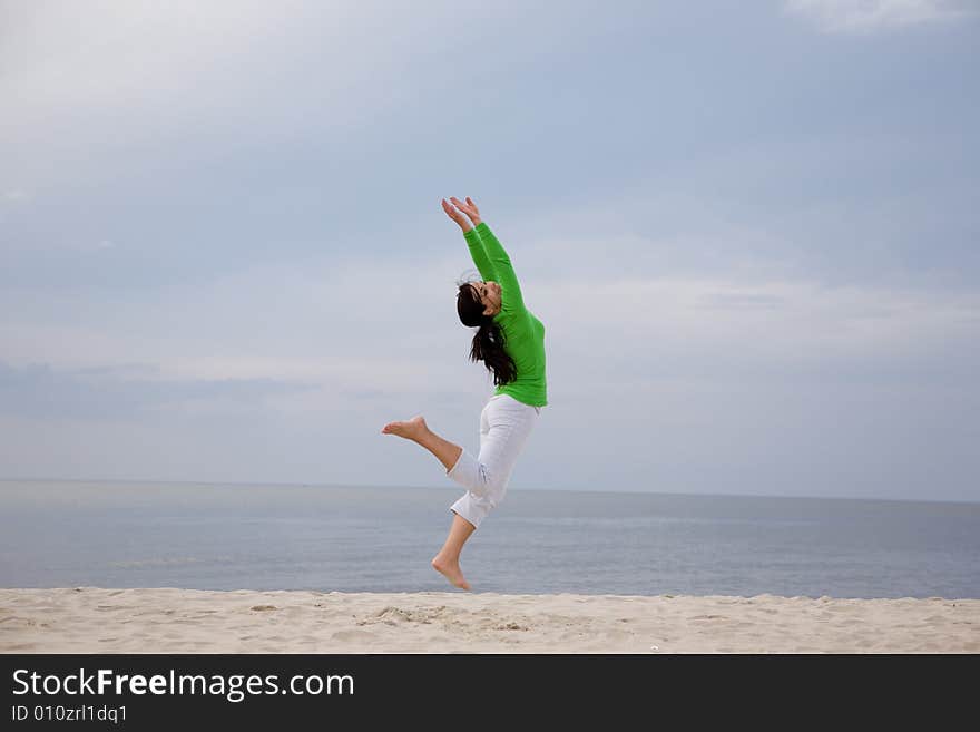 Active woman jumping on the beach. Active woman jumping on the beach