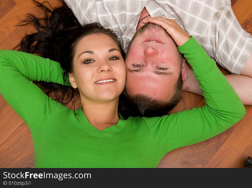 Happy couple lying on floor