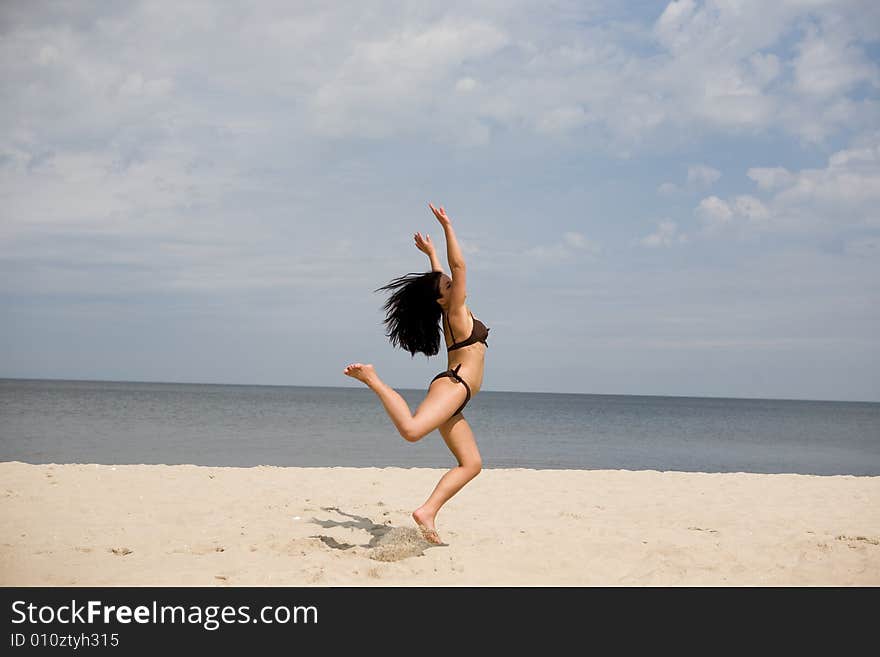 Active woman jumping on the beach. Active woman jumping on the beach