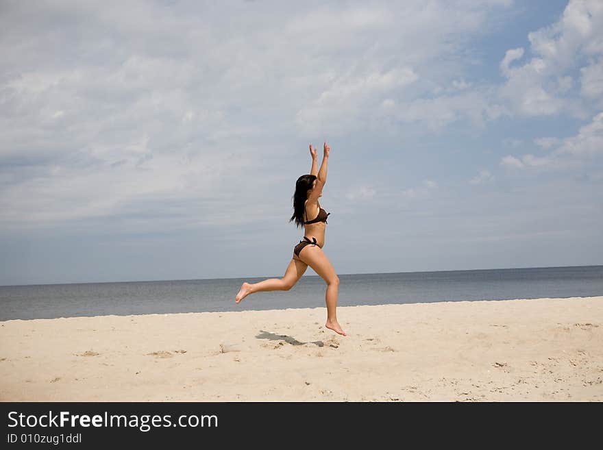 Active woman jumping on the beach. Active woman jumping on the beach