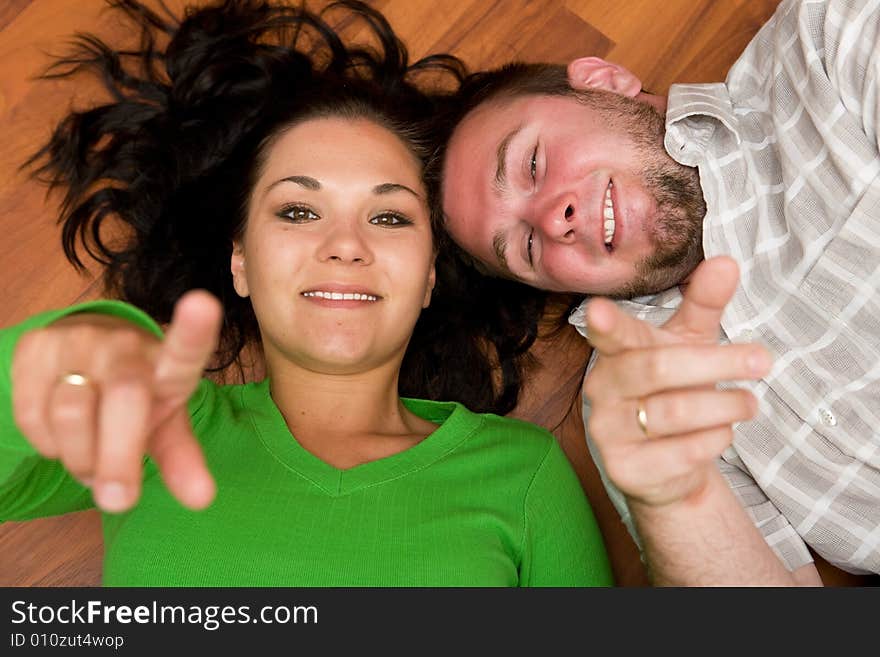 Happy couple lying on floor