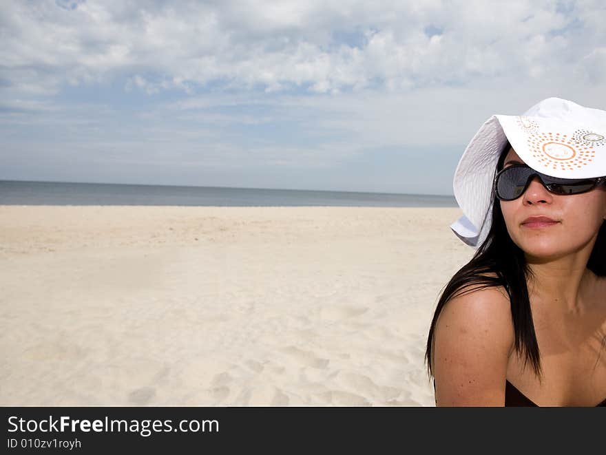 Attractive brunette woman relaxing on beach. Attractive brunette woman relaxing on beach